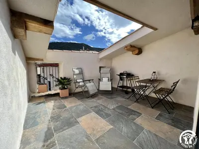 a patio with a table and chairs and a window at Helena in Quintillan