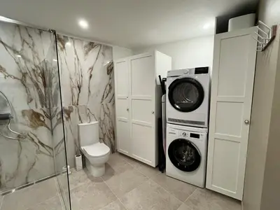 a bathroom with a toilet and a washer and dryer at Helena in Quintillan