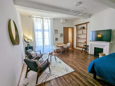 a bedroom with a bed and a living room at Studio cosy et spacieux in Carcassonne