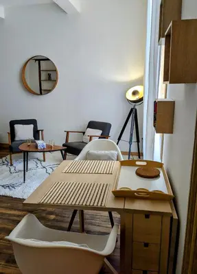 a room with a table and chairs and a mirror at Studio cosy et spacieux in Carcassonne