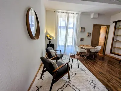a living room with a mirror and chairs and a table at Studio cosy et spacieux in Carcassonne