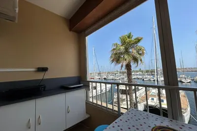 a room with a large window with a view of a marina at Charming studio with sea view Gruissan in Gruissan