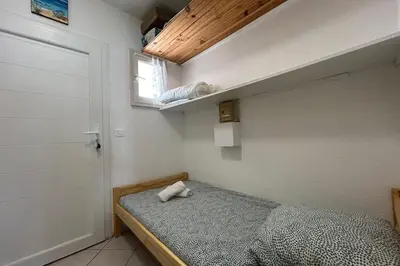 a small bedroom with a bed and a window at Charming studio with sea view Gruissan in Gruissan