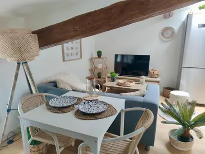a living room with a table and a blue couch at AppartZen proche Cité de Carcassonne et lac de la Cavayère in Trèbes