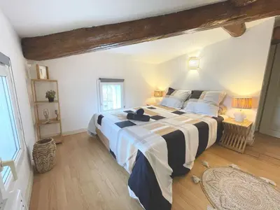 a bedroom with a large bed with black and white sheets at AppartZen proche Cité de Carcassonne et lac de la Cavayère in Trèbes