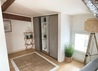 a living room with a book shelf and a window at AppartZen proche Cité de Carcassonne et lac de la Cavayère in Trèbes