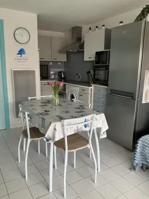 a kitchen with a table with chairs and a refrigerator at Bleu Riviera Lumière, Calme et Air Marin in Port-la-Nouvelle