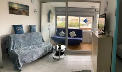 a living room with a bed and a couch at Bleu Riviera Lumière, Calme et Air Marin in Port-la-Nouvelle