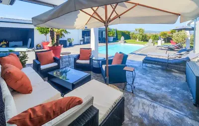 a patio with couches and an umbrella and a pool at Cozy Home In La Redorte in La Redorte