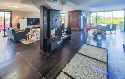 a living room with a fireplace and a kitchen and a living room at Cozy Home In La Redorte in La Redorte