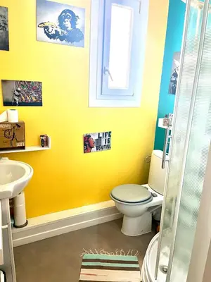 a yellow bathroom with a toilet and a sink at La Maison Nikaïa in Narbonne