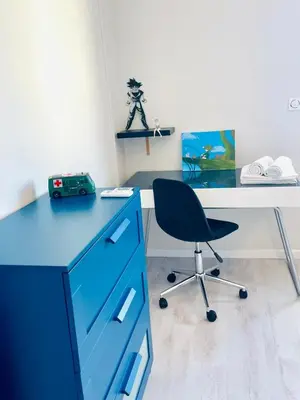 an office with a blue desk and a chair at La Maison Nikaïa in Narbonne