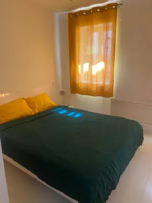 a bedroom with a green bed with a window at Chambre privée en centre-ville in Trèbes