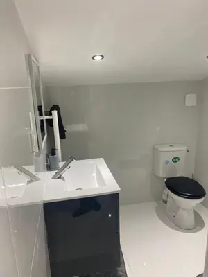 a white bathroom with a toilet and a sink at Chambre privée en centre-ville in Trèbes