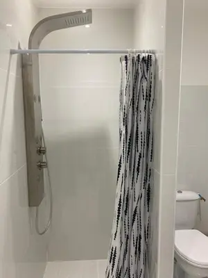 a shower with a black and white shower curtain in a bathroom at Chambre privée en centre-ville in Trèbes