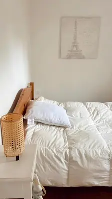 a bedroom with a white bed with the eiffel tower at Appartement Malibu in Lapalme