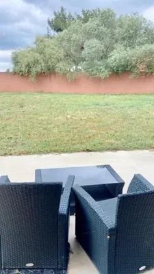 a picnic table and two chairs on a sidewalk at Appartement Malibu in Lapalme