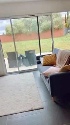 a living room with a couch and a large window at Appartement Malibu in Lapalme