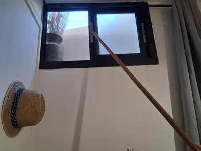 a window with two mop and a hat in a room at Studio Robine les halles avec clim in Narbonne