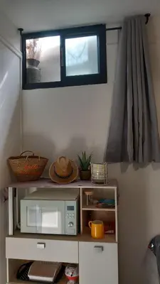 a small kitchen with a microwave and a window at Studio Robine les halles avec clim in Narbonne