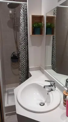 a bathroom with a white sink and a shower at Studio Robine les halles avec clim in Narbonne