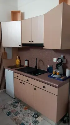 a kitchen with white cabinets and a sink at Studio Robine les halles avec clim in Narbonne