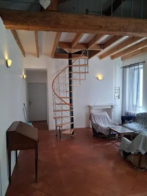 a living room with a spiral staircase in a room at Chez Sylvie in Carcassonne