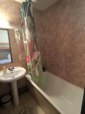 a bathroom with a sink and a tub and a toilet and a mirror at Location de vacances bord de mer Gruissan in Gruissan