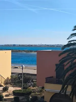 a view of the beach from the balcony of a building at Location de vacances bord de mer Gruissan in Gruissan