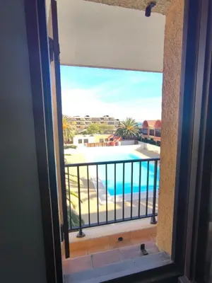 a view of a pool from a window at Location de vacances bord de mer Gruissan in Gruissan