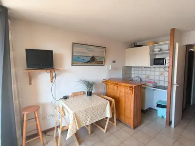a kitchen with a table and a small kitchen with a table and chairs at Location de vacances bord de mer Gruissan in Gruissan