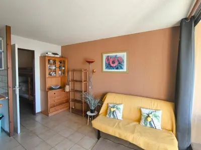 a living room with a yellow couch in a room at Location de vacances bord de mer Gruissan in Gruissan