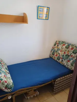 a bed sitting in a corner of a room at Location de vacances bord de mer Gruissan in Gruissan