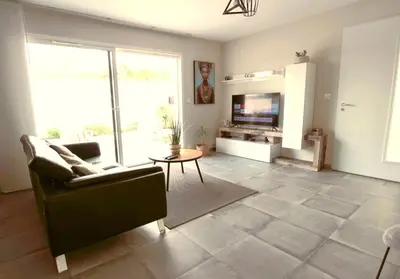 a living room with a couch and a tv at Maison T3 in Sallèles-dʼAude