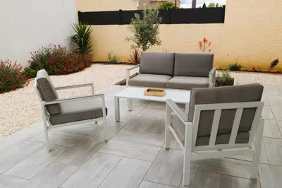 two chairs and a table and a couch on a patio at Maison T3 in Sallèles-dʼAude