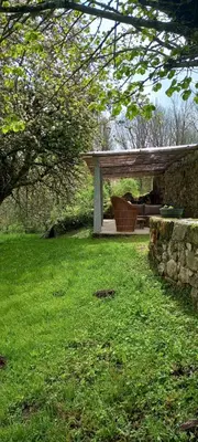 a picnic table in a field with a stone wall at Gîte familial 10 places in Castelnau-de-Brassac