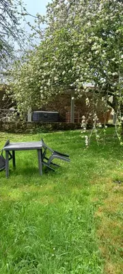 a picnic table sitting in the grass near a tree at Gîte familial 10 places in Castelnau-de-Brassac