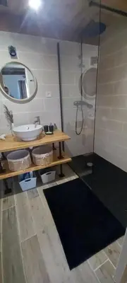 a bathroom with a sink and a shower with a mirror at Gîte familial 10 places in Castelnau-de-Brassac
