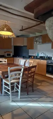 a kitchen with a wooden table and a dining room at Gîte familial 10 places in Castelnau-de-Brassac
