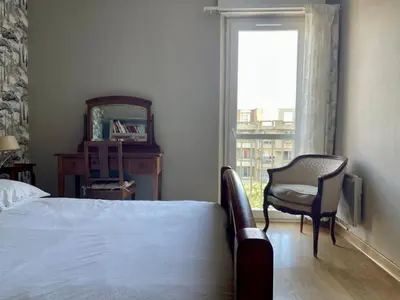 a bedroom with a bed and a chair and a window at Le Vintage des Oliviers - Vue Aude ascenseur et parking in Carcassonne