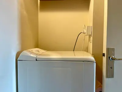a small white refrigerator in a corner of a room at Le Vintage des Oliviers - Vue Aude ascenseur et parking in Carcassonne