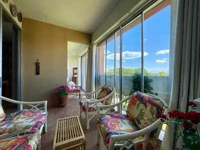 a balcony with chairs and a couch and windows at Le Vintage des Oliviers - Vue Aude ascenseur et parking in Carcassonne