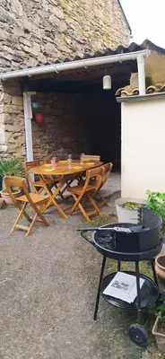 a wooden table and chairs outside of a building at Villa hameau paisible Ardouane, à côté voie verte in Riols