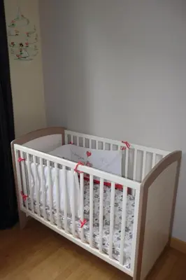 a white crib in a room with at Villa hameau paisible Ardouane, à côté voie verte in Riols