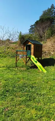 a playground with a slide in a field at Villa hameau paisible Ardouane, à côté voie verte in Riols