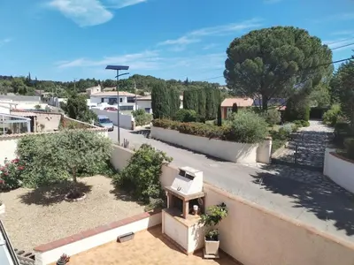 a view of a garden from a balcony at Lumineuse villa au pied de la pinède in Lézignan-Corbières