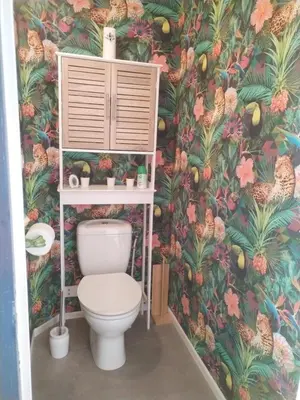 a bathroom with a toilet with a tropical wallpaper at Lumineuse villa au pied de la pinède in Lézignan-Corbières