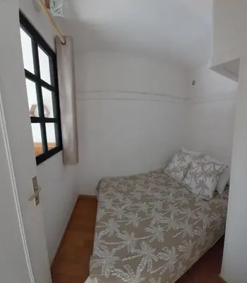 a small bedroom with a bed and a window at La Maison de la Plage in Port-la-Nouvelle