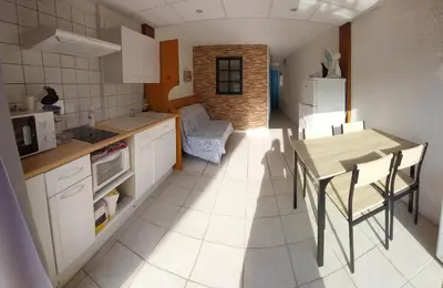 a kitchen and dining room with a table and chairs at La Maison de la Plage in Port-la-Nouvelle