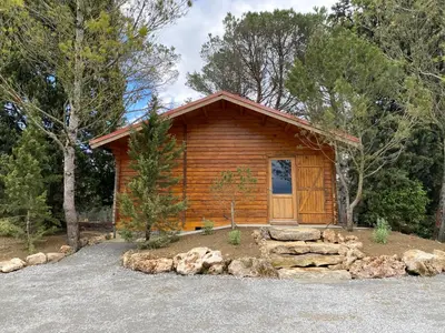 a log cabin in the woods with a pile of rocks at Échappée Vigneronne in Pennautier